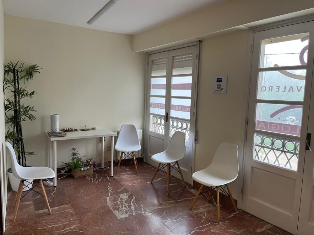 Sala de espera del Centro de Psicología Dolores Valero, en la Plaza Mayor de Lugo: sillas blancas, una planta y la galería que da a la plaza